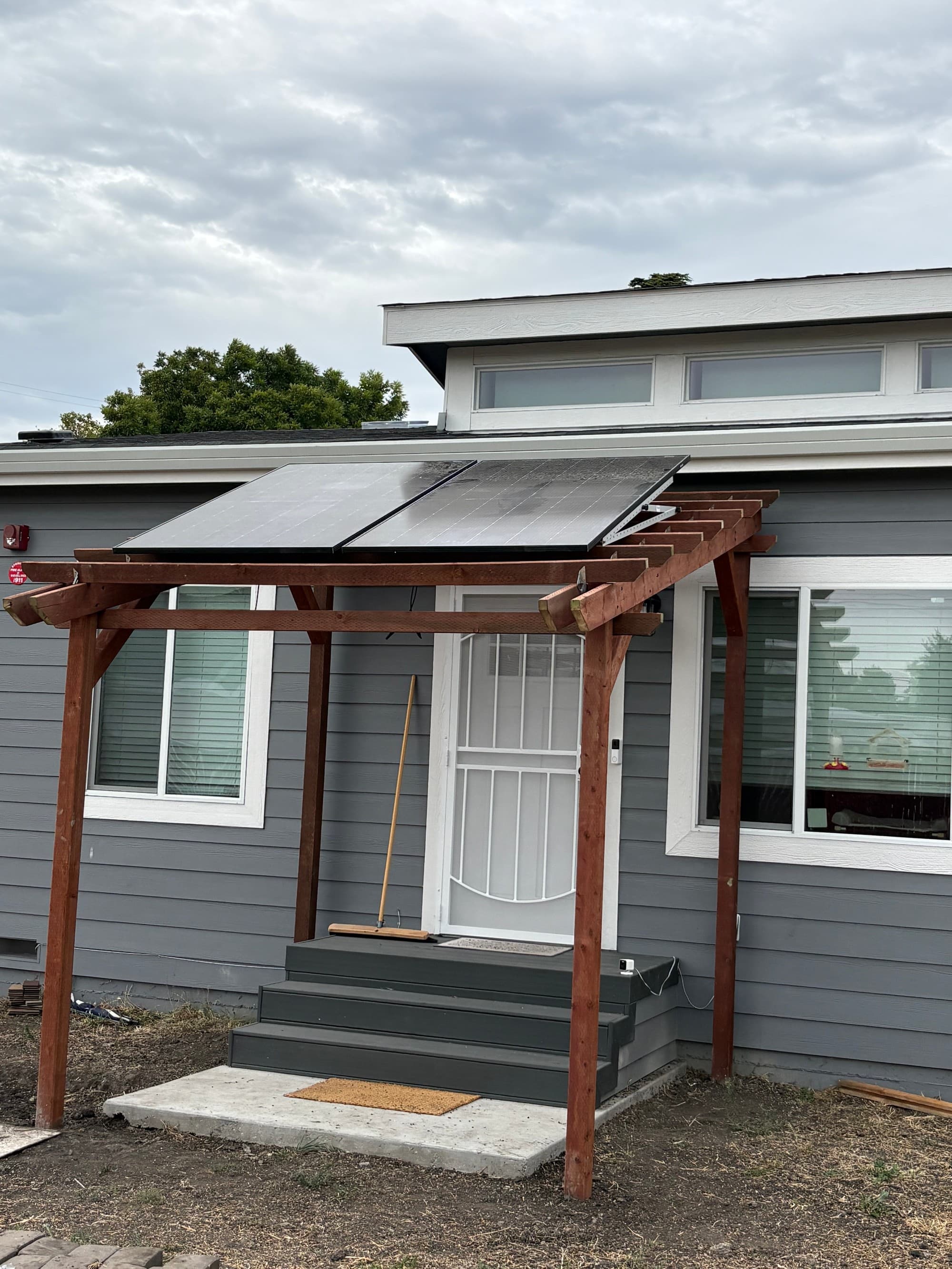 Solar + battery backup — custom install Solar panels on a custom wood pergola designed and built by Astral Electrical over a home's entry — solar-plus-battery install by Astral, licensed C-10 #1114918.